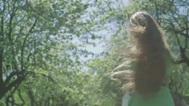 Κορίτσι με μακριά κόκκινα μαλλιά στον κήπο της apple — Αρχείο Βίντεο