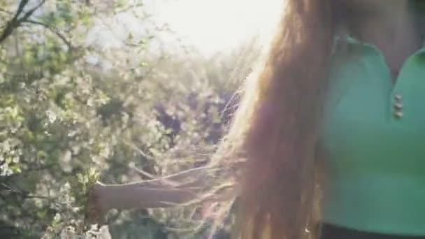 Ragazza con lunghi capelli rossi nel giardino delle mele — Video Stock