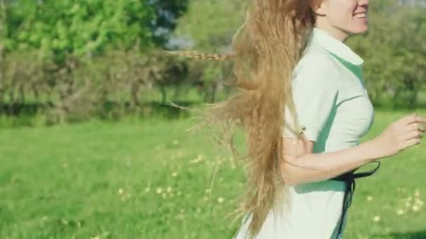 Chica con el pelo largo y rojo divertirse en el parque — Vídeo de stock