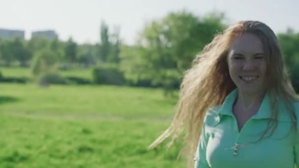 Chica con el pelo largo y rojo divertirse en el parque — Vídeo de stock