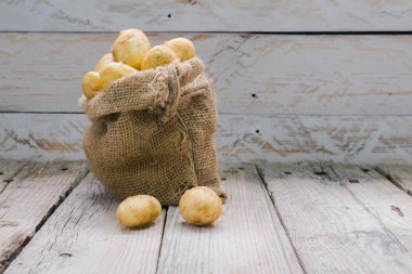 Tahta bir masada taze organik patates.