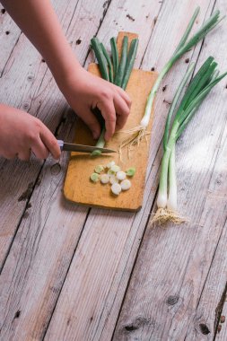 Yeşil soğan bir ahşap arka plan üzerinde kesme