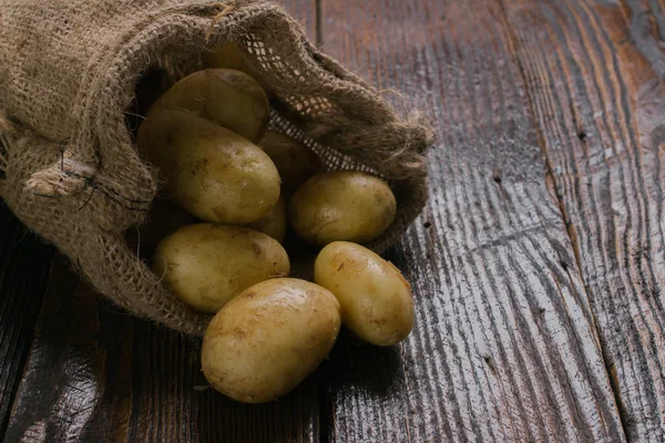 Свежий органический картофель на деревянном столе — стоковое фото