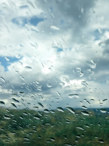 Fondo de gotas de lluvia en un cristal de la ventana en un día lluvioso — Foto de Stock