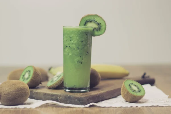 Green kiwi smoothie on wooden table — Stock Photo, Image