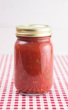 Kırmızı Gingham Masa örtüsü üzerinde salsa. Ev Canning Kavanozunda.
