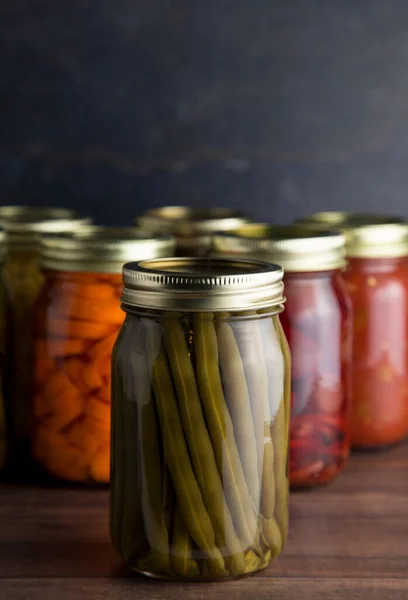 Vários Tipos Vegetais Enlatados Uma Mesa Madeira Ambiente Escuro — Fotografia de Stock