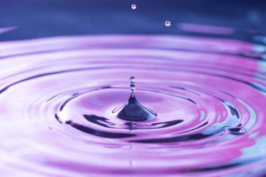 Sivri Su Damlacıkları Mor Yansımalı Bir Su Havuzu 'na