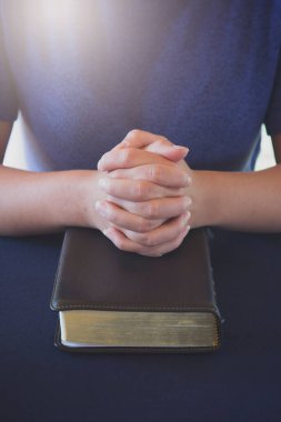 İncil okuyan ve dua eden genç insan.