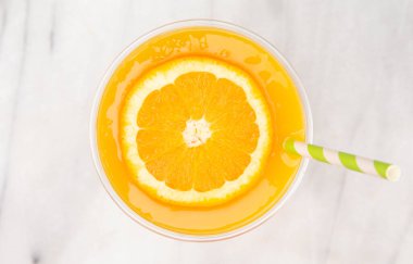 Plastik bir kullan-at bardağa taze sıkılmış portakal suyu. 