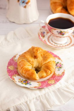 Taze pişmiş tereyağlı kruvasan Sıcak Siyah Kahveyle Kahvaltı Masasına Yattı
