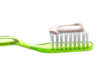 Diş fırçasıyla beyaz bir arkaplan üzerinde diş macunu uygulanan basit bir diş fırçası