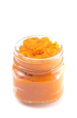 Portakal aromalı sebze püresiyle dolu bir cam kavanoz.