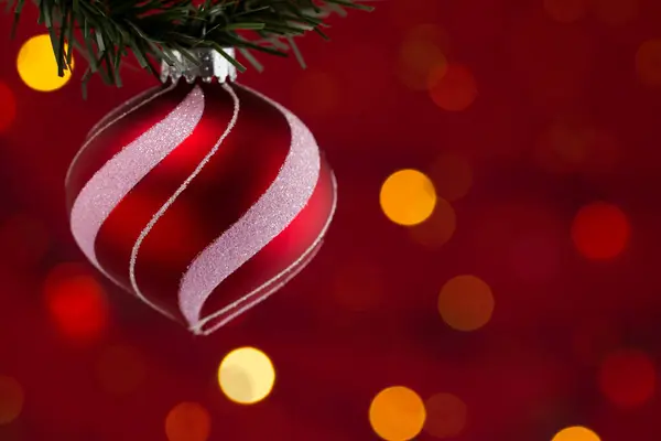 赤い背景を持つクリスマスの飾りをぶら下げる — ストック写真