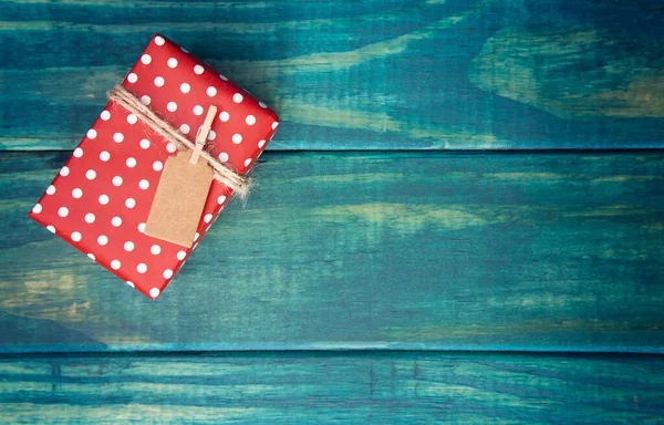 木桌上贴有礼物标签的单个包装圣诞礼物 — 图库照片