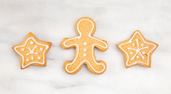 Three Gingerbread Cookies in a Row on a Marble Counter