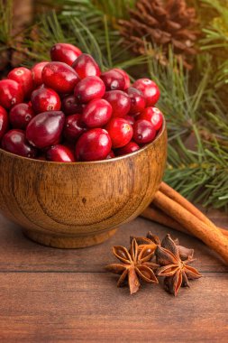Tahta bir masada taze yuvarlak kırmızı kızılcık kasesi.