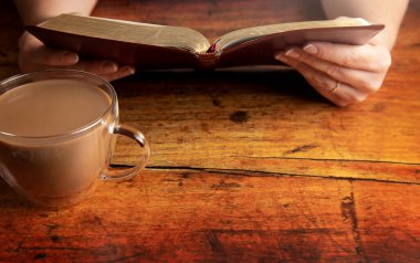 Kırsal Ahşap Masa 'da İncil okuyan bir kadın.