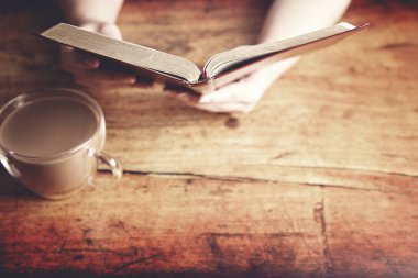 Kırsal Ahşap Masa 'da İncil okuyan bir kadın.