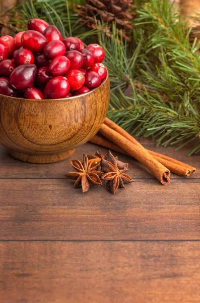 Tahta bir masada taze yuvarlak kırmızı kızılcık kasesi.
