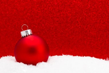 Arkaplanı ışıltılı olan Kardaki Noel Süsü