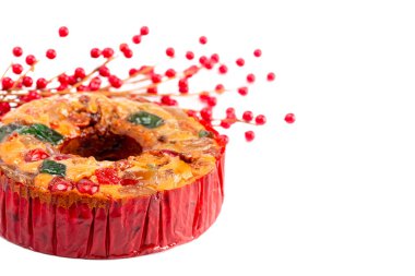 Beyaz bir arkaplanda kiraz, ananas ve fındıklı yuvarlak meyveli kek.