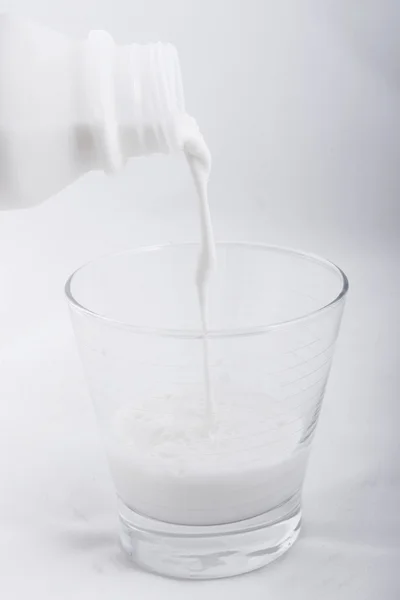 Nalévání čerstvého mléka do skla — Stock fotografie