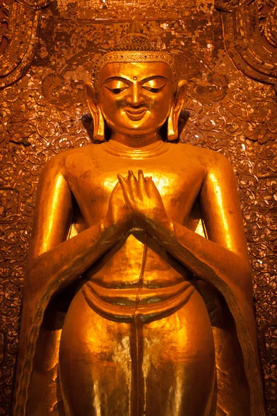 BAGAN, MYANMAR - MAT 4: Buda de pé Kassapa no lado sul do templo de Ananda adornado pelos crentes colando folhas douradas na estátua em 4 de maio de 2013 em Bagan, Mianmar . — Fotografia de Stock