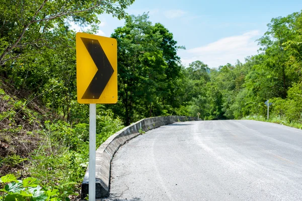 Winding road sign in the forest and mountain — Stock Photo, Image