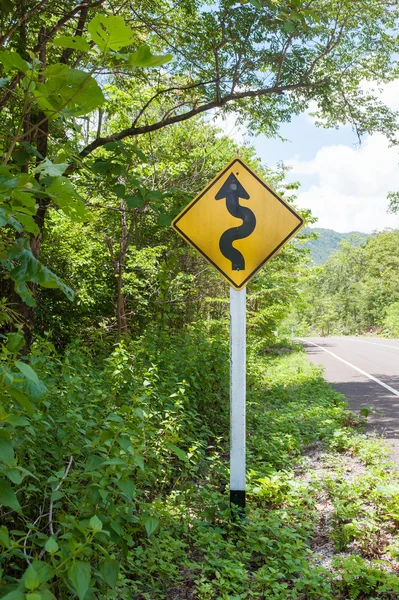 Winding road sign in the forest and mountain — Stock Photo, Image