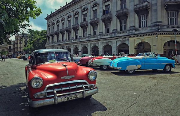 CUBA, LA HABANA-10 DE JULIO DE 2015: Viejos autos americanos en el estacionamiento frente al Capitolio. Estos coches de época son un icono de la Cuba — Foto de Stock