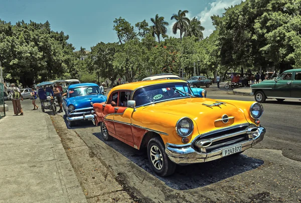 CUBA, HAVANA-JULHO 10, 2015: Carro americano amarelo clássico em uma rua em Havana. Os cubanos usam os carros retro como táxis para turistas Imagens Royalty-Free