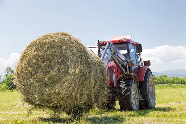 Traktor, sbírání balíků slámy — Stock fotografie