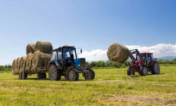 Traktor, sbírání balíků slámy — Stock fotografie
