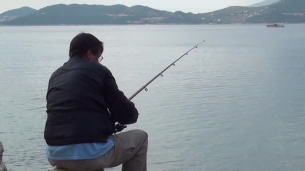 Mens vissen vanaf de kliffen — Stockvideo