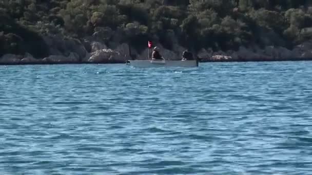 Barco pequeño con dos personas pasando — Vídeo de stock