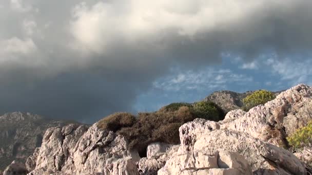 Опускающиеся облака солнце и камни — стоковое видео