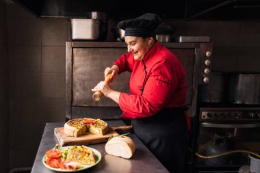 Lokanta mutfağında çalışan bir kadın telefonunu kullanmak için mola vermiş..