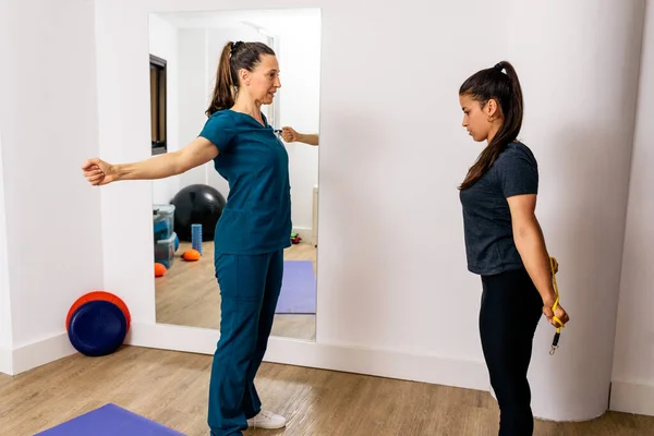 Profesyonel bir işçiyle rehabilitasyon egzersizleri yapan bir kadının stok fotoğrafı..