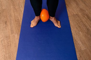 Fizyoterapi kliniğinde mavi hasırla egzersiz yapan tanınmamış birinin resmi..