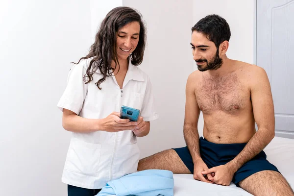 Foto Stock Fisioterapeuta Con Teléfono Móvil Hablando Con Paciente Sentado —  Fotos de Stock