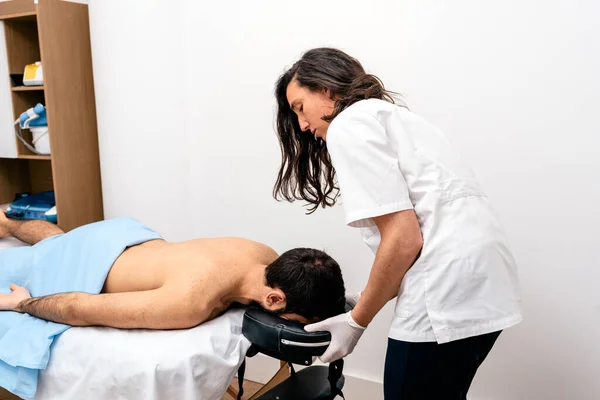 Stock photo of man receiving massage by physiotherapist professional.