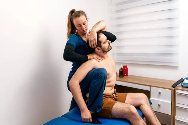 Foto Stock Fisioterapeuta Dando Masaje Espalda Paciente Sentado Camilla —  Fotos de Stock