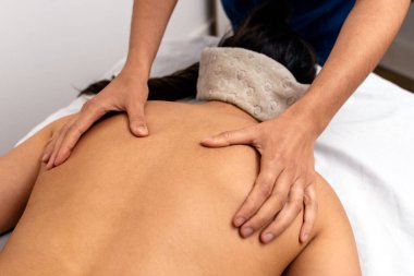 Tanımlanamayan bir kadının sedyede yatan hastaya sırt masajı yapması..