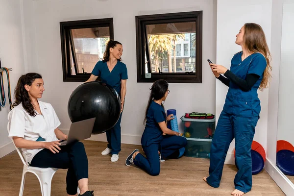 Fizyoterapi kliniğinde çalışan mutlu kadınlardan oluşan birleşik çalışma ekibinin resmi..