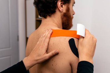 Sedyede oturan hastaya sırt masajı yapan fizyoterapistin stok fotoğrafı..