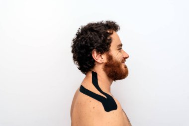 Tedavi sırasında ayakta duran ve ön tarafa bakan sakallı adamın resmi..