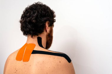 Tedavi sırasında sırtüstü duran sakallı adamın resmi..