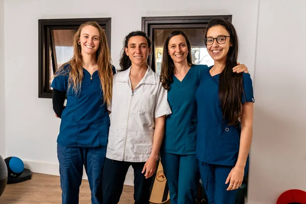Fizyoterapi kliniğinde çalışan mutlu kadınlardan oluşan birleşik çalışma ekibinin fotoğrafı..