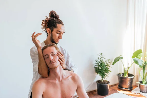 Foto Stock Uomo Rilassato Godendo Massaggio Collo Mentre Seduto Asciugamano — Foto Stock